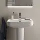 Waschtisch von Ideal Standard mit rechteckiger Form, moderner Armatur und Handtuchhalter, auf heller Wand montiert, mit Zubehör wie Zahnbürstenhalter und Seife.